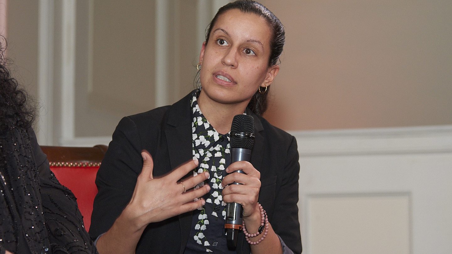 Close up of City Council Member Tiffany Cabán holding the microphone and talking.