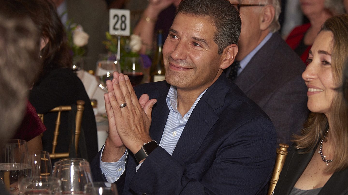 Osborne board member John Valverde smiling with his hands clasped together.