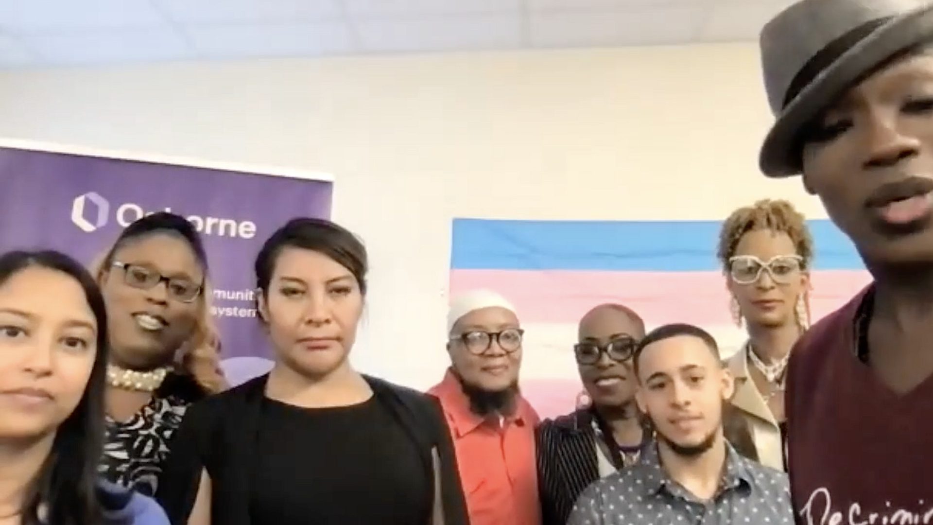 Speakers standing next to each other looking at the screen.